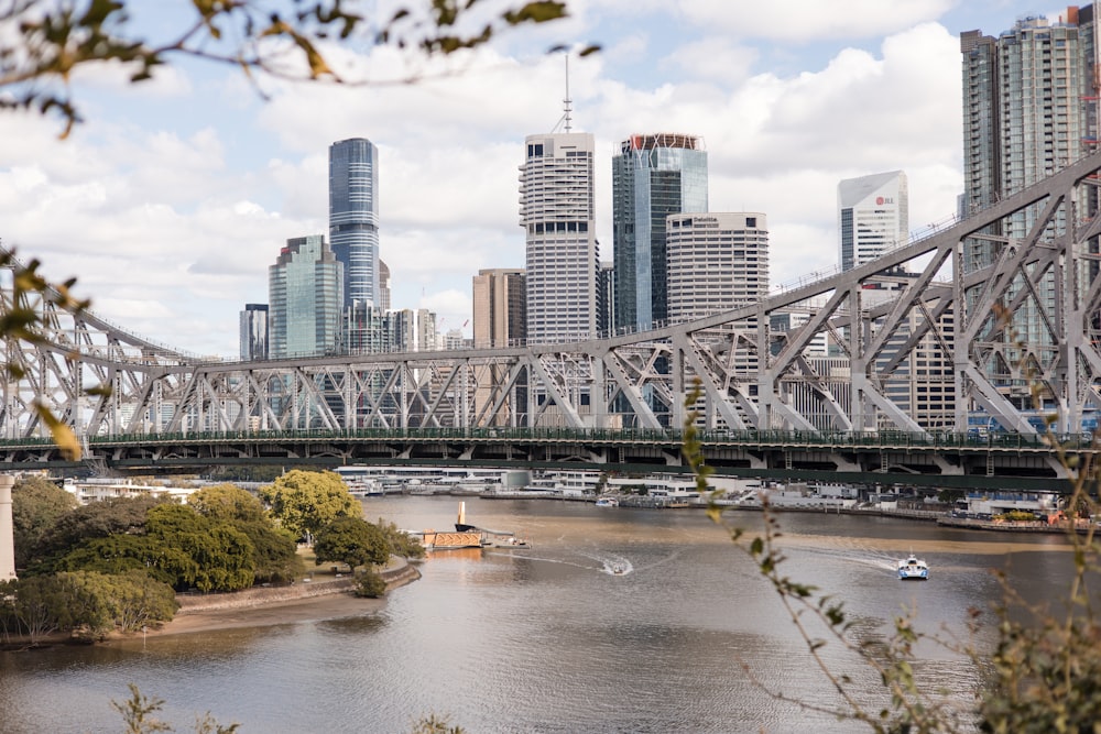 a bridge over a river with a city in the background