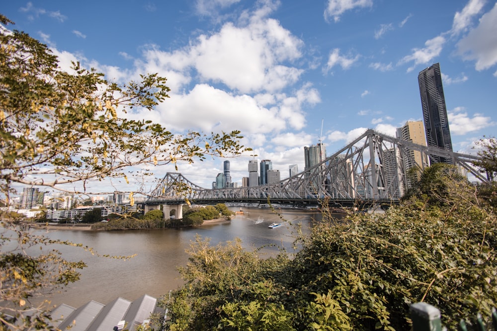 a bridge over a river with a city in the background