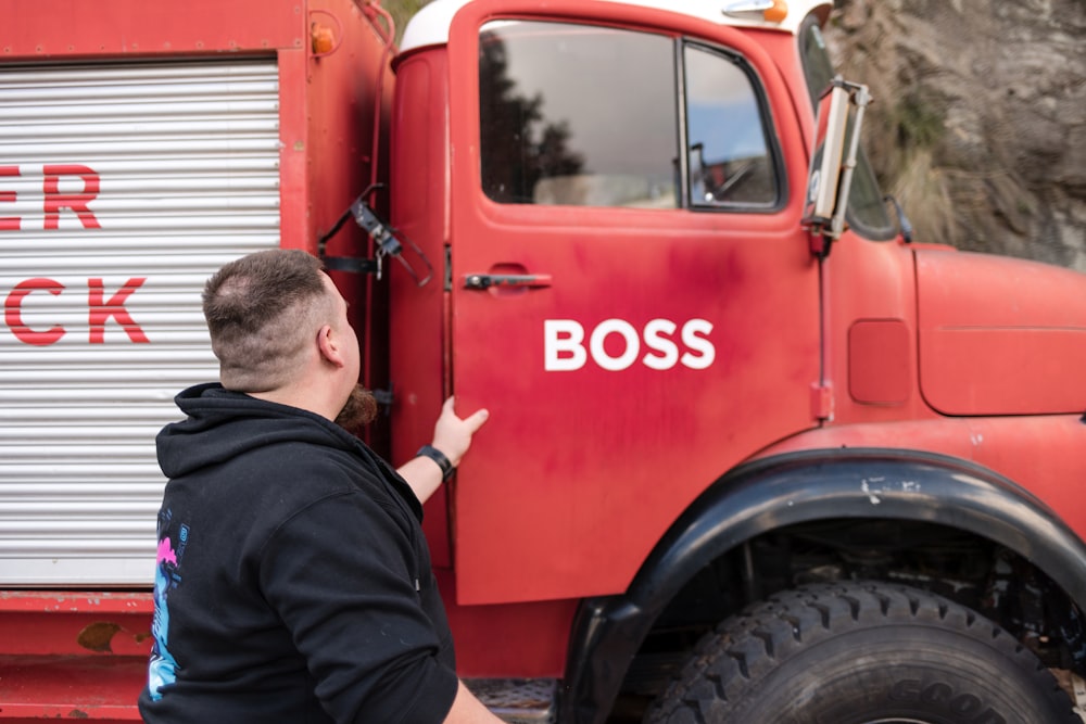 a man standing next to a red truck