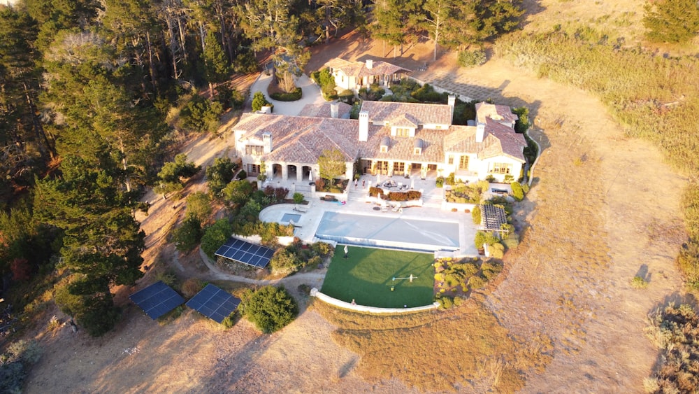 a large house with a pool in the middle of a dirt field