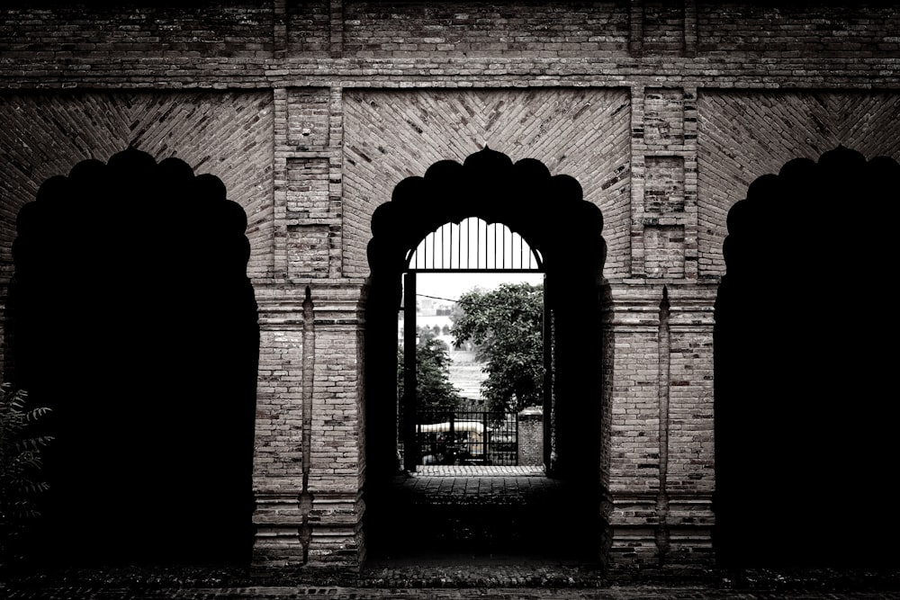 a dark brick building with a large arched doorway