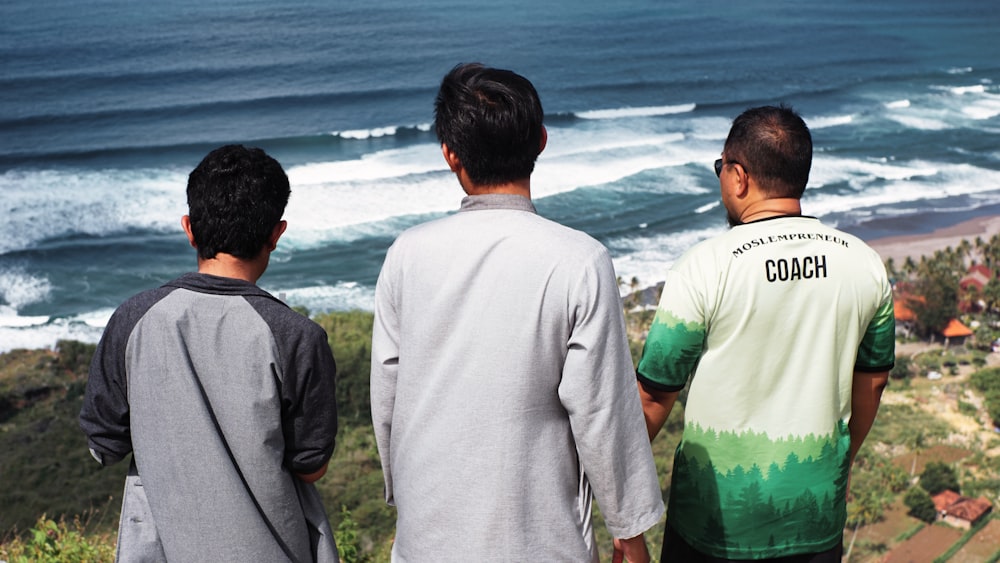 a group of men looking at the ocean