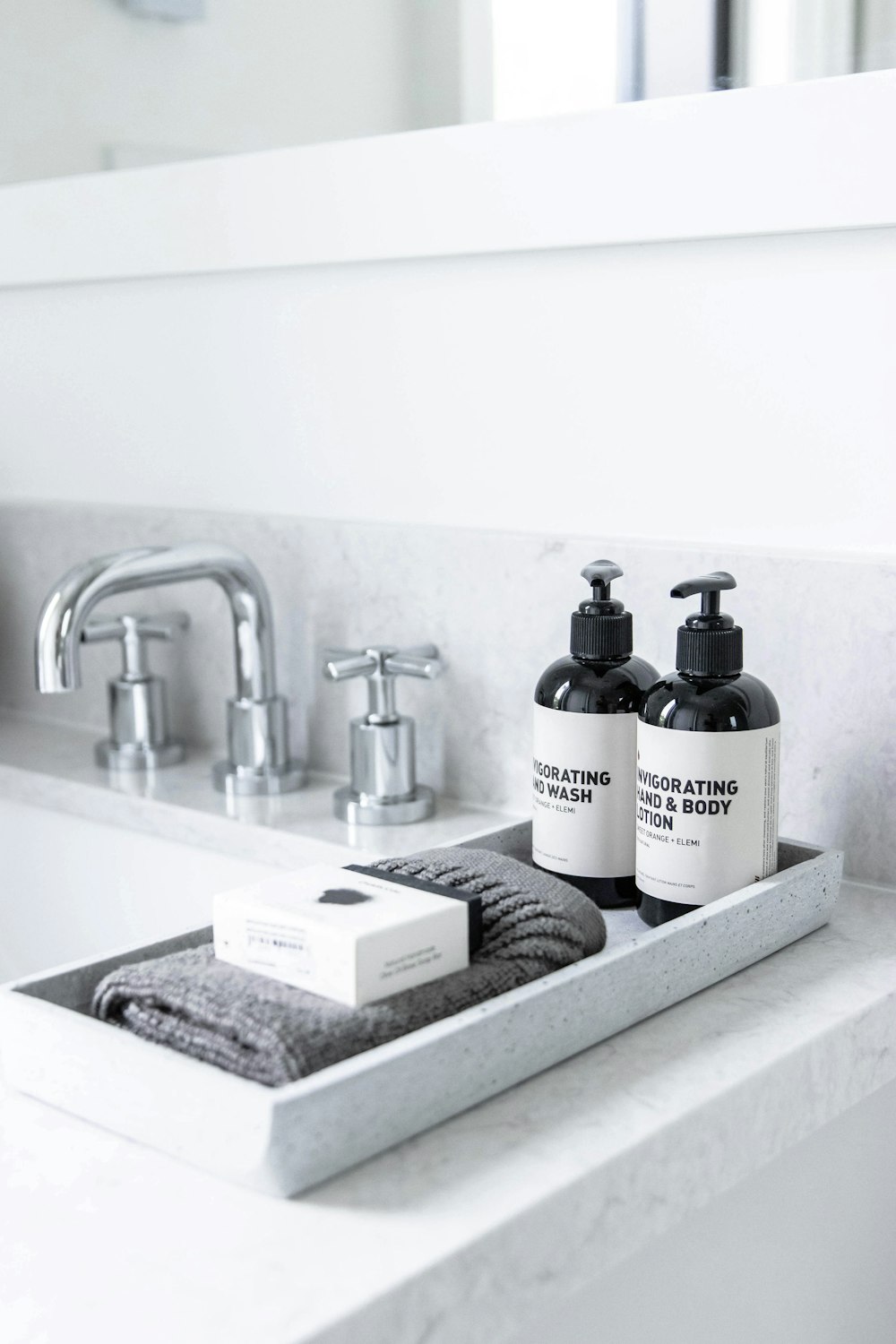 a sink with bottles of soap and a box of soap