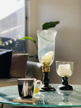 A cozy morning scene with a cup of herbal tea, a soft blanket, and a glowing candle on a wooden table.