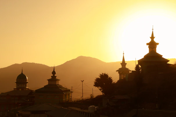 A serene view of a temple silhouetted against a golden sunset sky