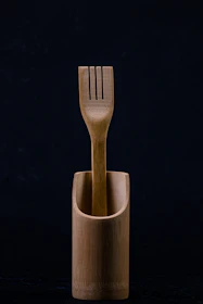 Wooden cutlery displayed alongside compostable food containers.