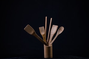 Bamboo utensil crock holding assorted kitchen tools on a wooden countertop