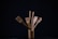 Close-up of bamboo utensil crock holding wooden spoons and kitchen tools on a rustic countertop.