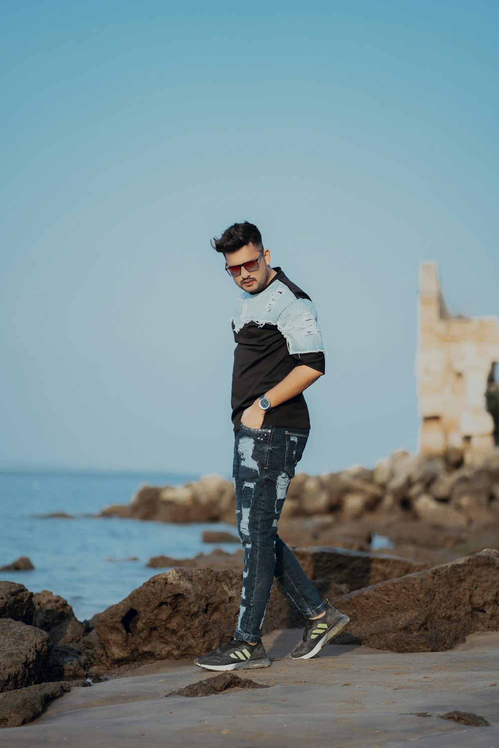 a man standing on a rock by the water