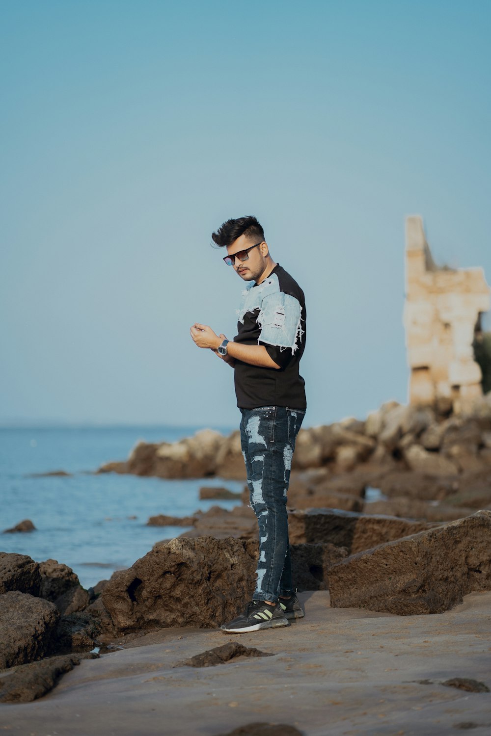 a man standing on a rock by the water