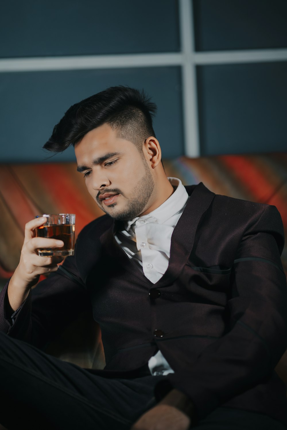 a man in a suit holding a glass of beer