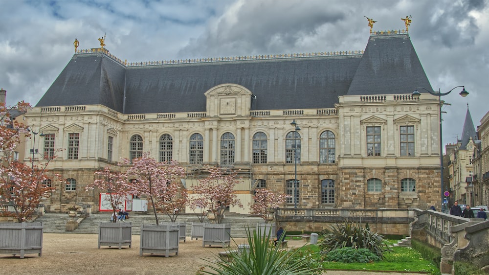 a large building with a courtyard and trees in front of it