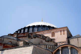 A historical building in Prishtina under a clear blue sky.