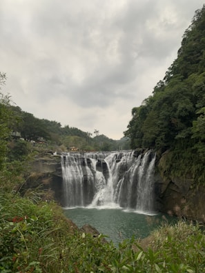 Scenic view of a serene waterfall in the Circuito das Águas Paulista during sunset.