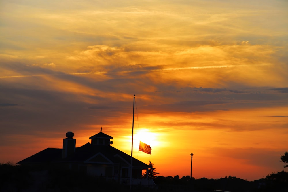 Une maison avec un drapeau à l’avant au coucher du soleil