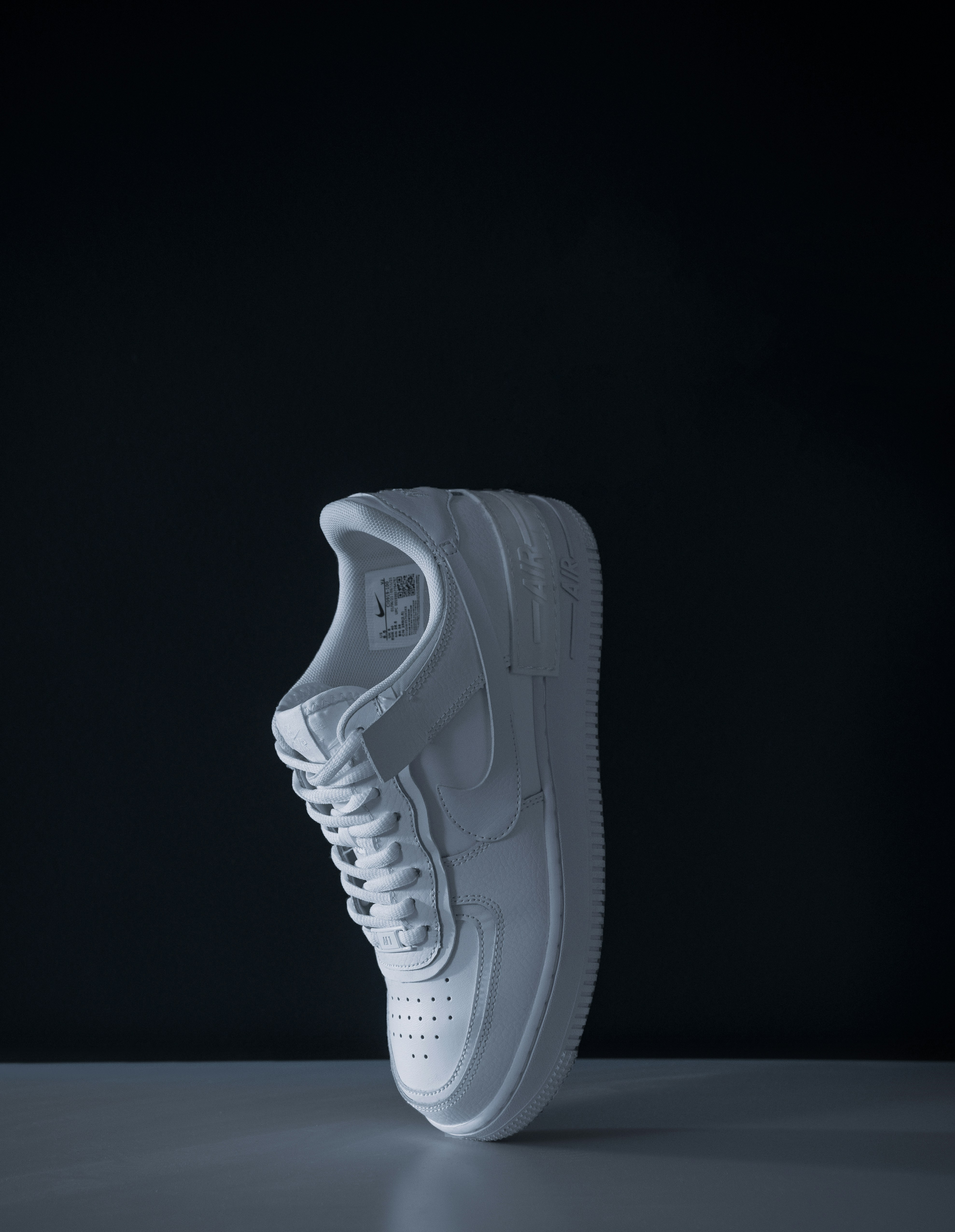 a white shoe on a black background