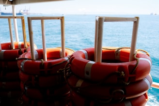 Close-up of liferafts and lifejackets neatly arranged on a ship deck.