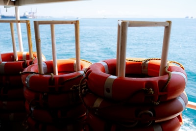 Close-up of liferafts and lifejackets neatly arranged on a ship deck.