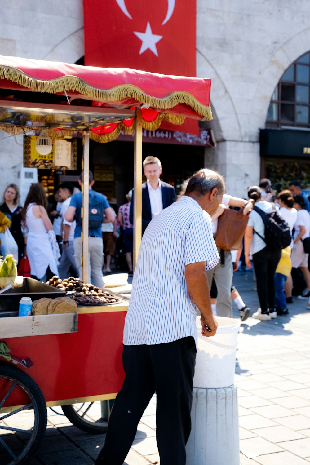 a man standing next to a food stand