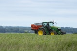 A tractor moving through the fields with the Kanvir Global logo visible.
