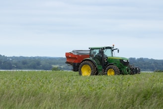 A modern John Deere tractor in a lush green field.