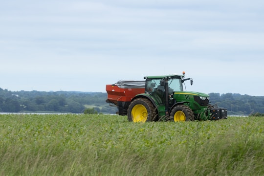 A rugged tractor fitted with new clutch and transmission parts operating in a lush green field.
