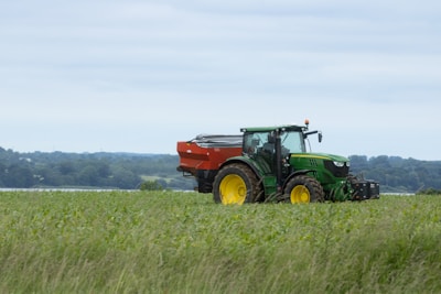 A modern John Deere tractor in a lush green field.
