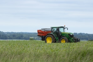 A rugged tractor equipped for agricultural work in a vast green field.