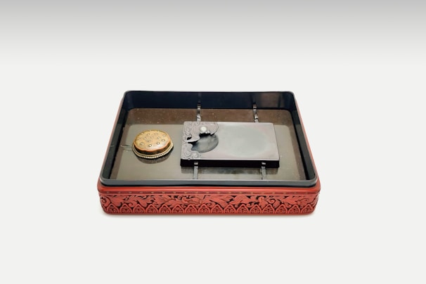 An open box showing various sizes and styles of hanko stamps with an earthy fabric lining.