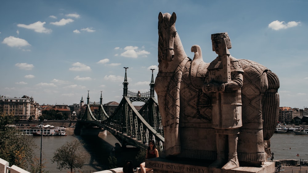 a group of statues by a river