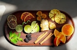 A spread of colorful fruits and herbal teas arranged on a wooden table.