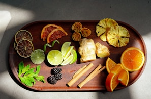 A colorful display of flaked fruits and herbs spread out on a wooden table with soft natural light