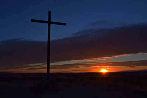 A sunset over Yuma with a cross silhouetted, symbolizing hope and revival.
