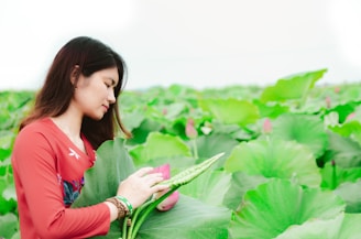 a woman looking at a leaf