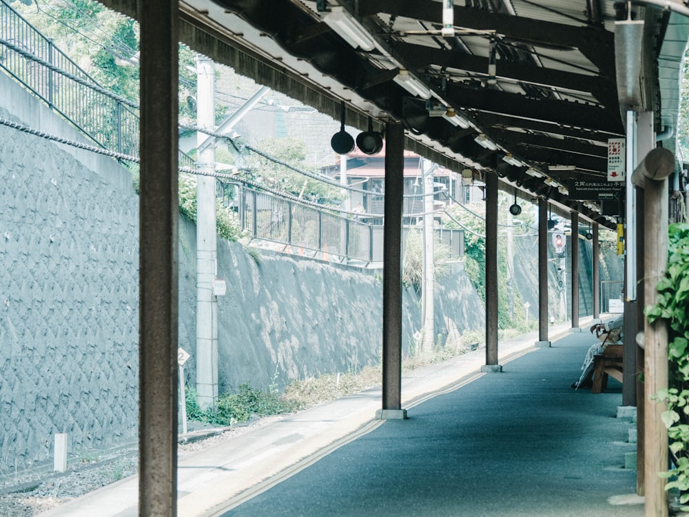 a walkway with a fence and a wall with a sign on it