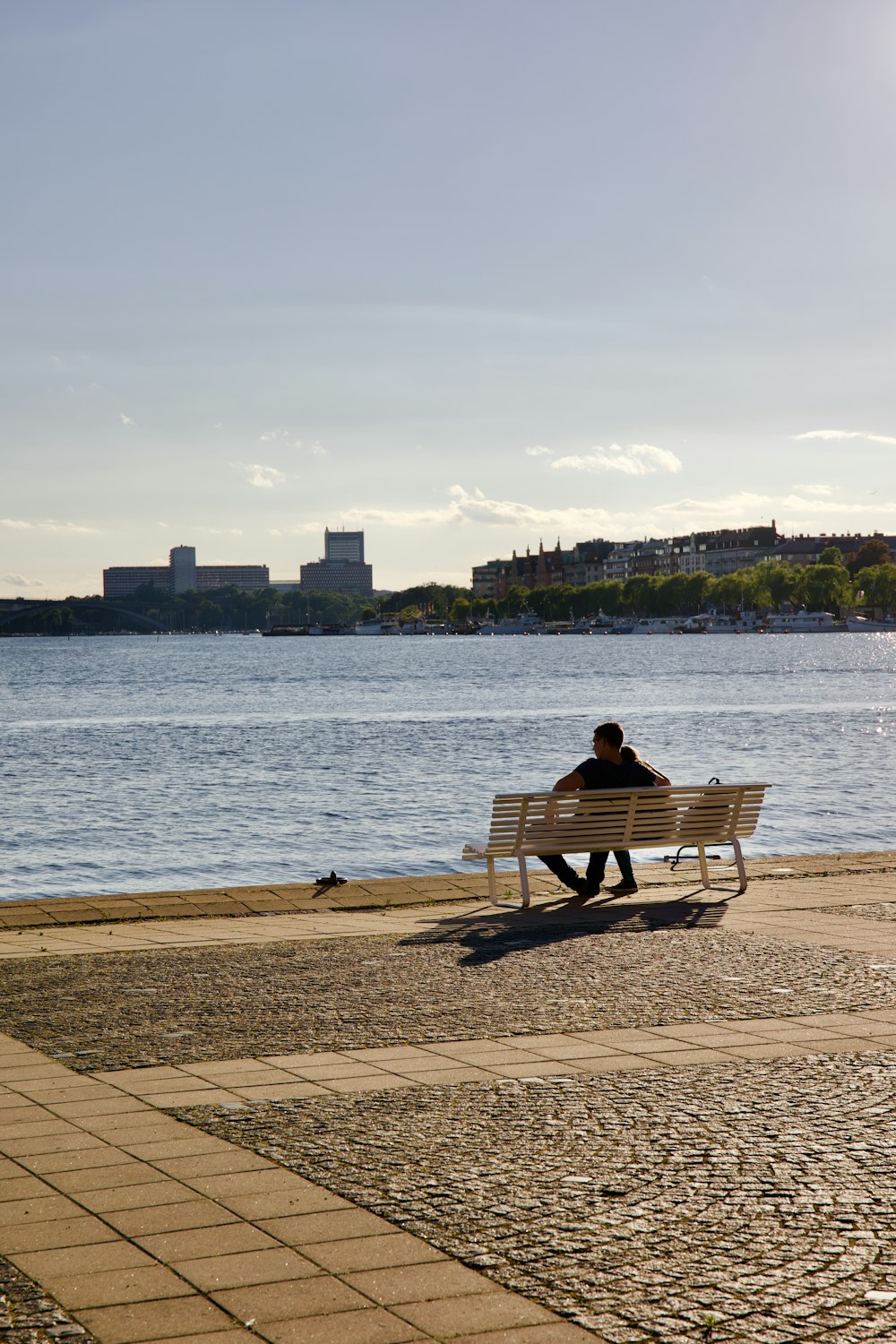a person sitting on a bench by the water