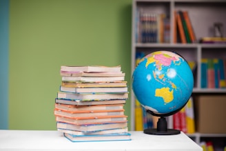 A stack of colorful educational books on a desk.