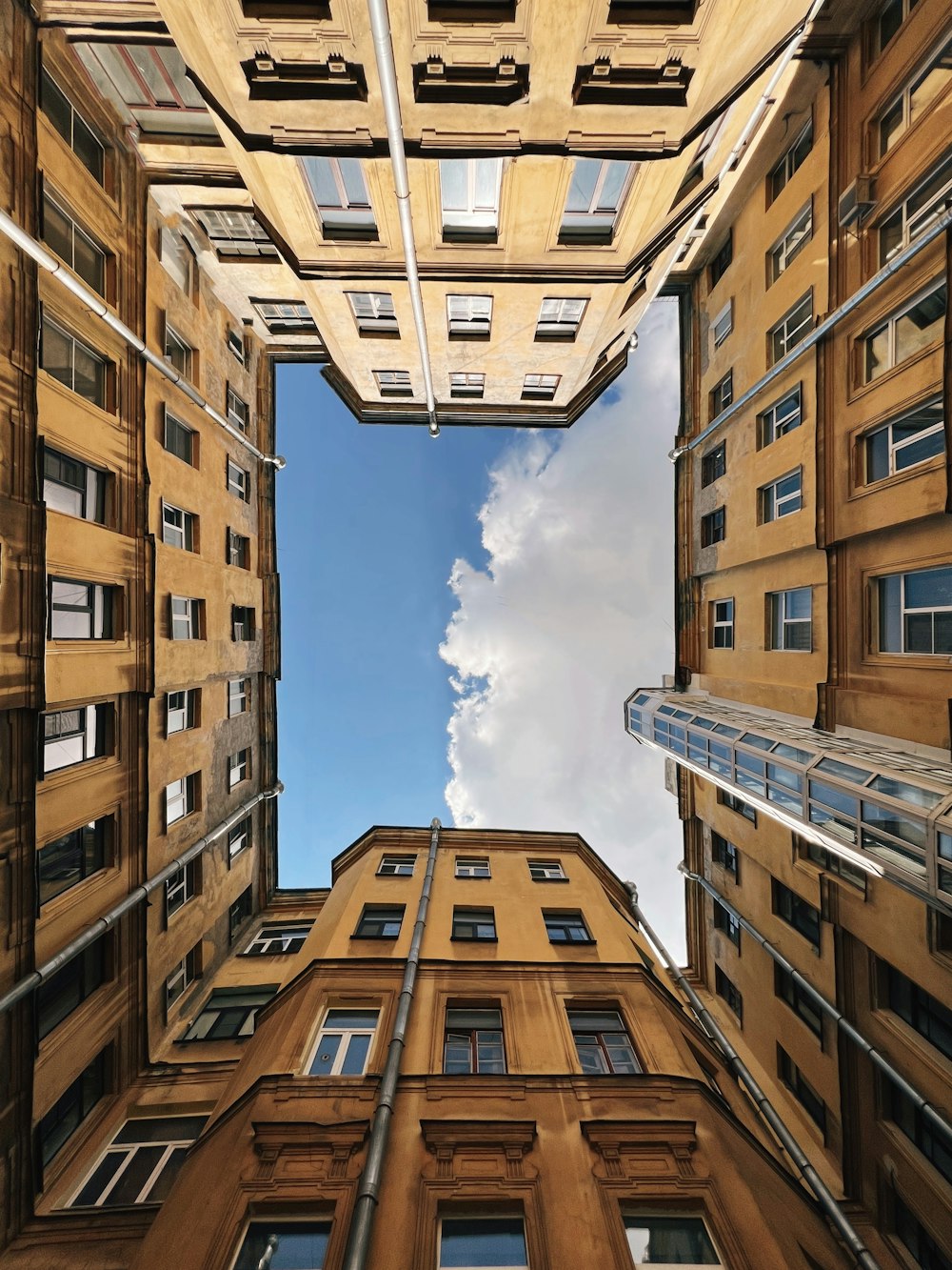 a view looking up at a tall building with a cloudy sky