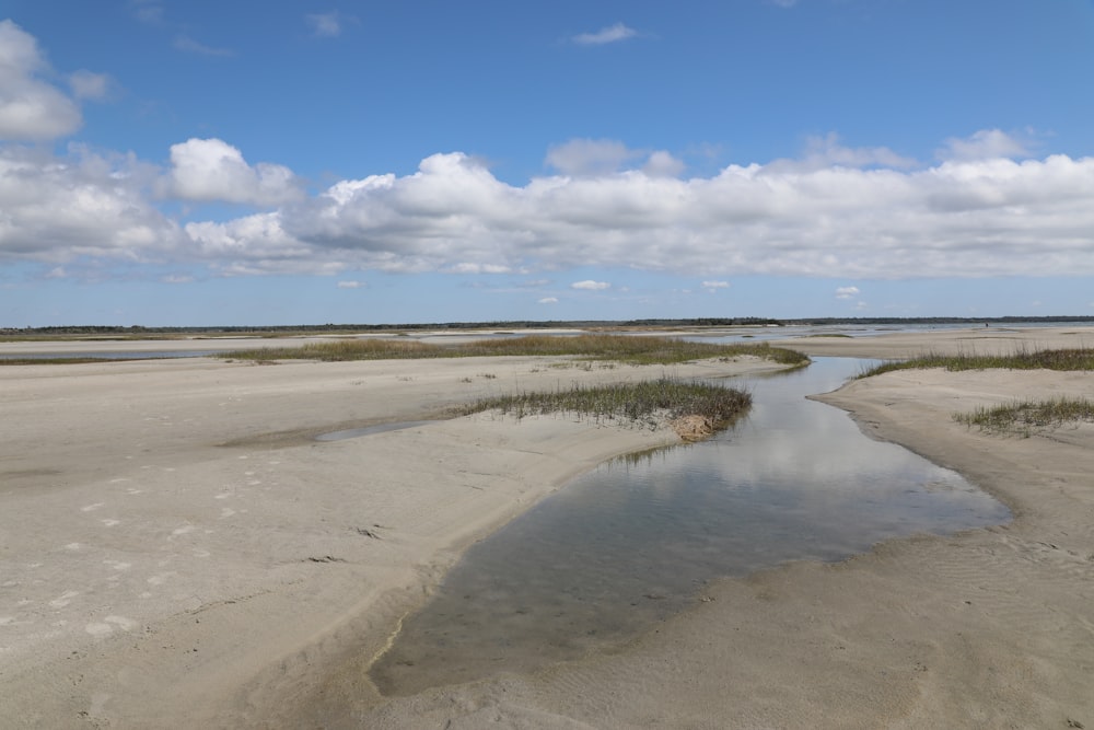 Una spiaggia di sabbia con acqua e cielo blu