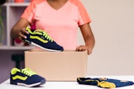 A volunteer handing over a box of shoes to excited kids at a community center in Lagos.