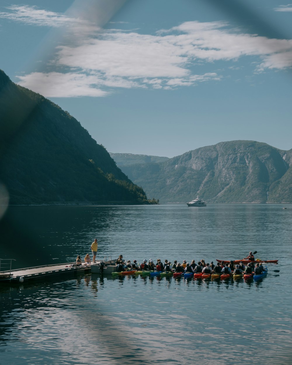 a group of people in a row boat on a lake