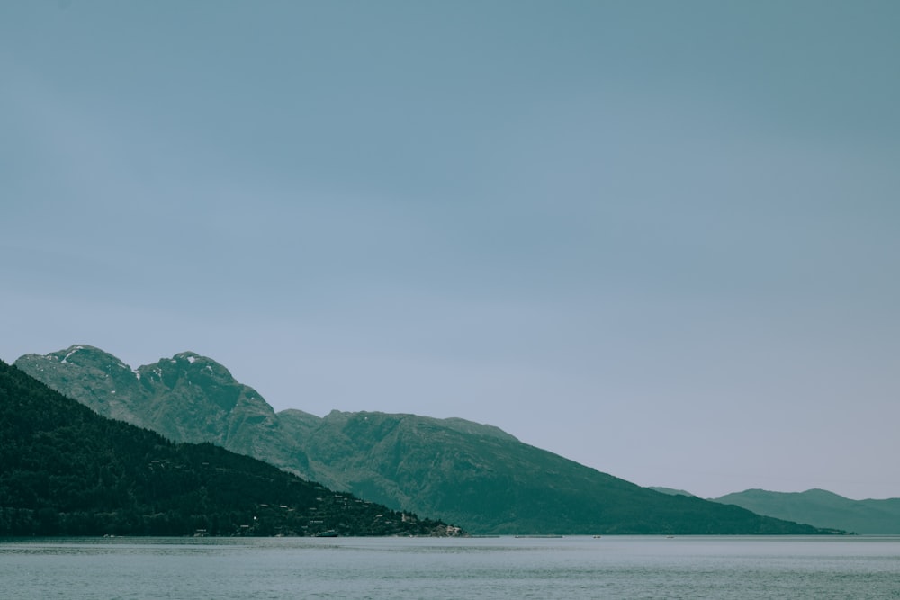 a body of water with a mountain in the background