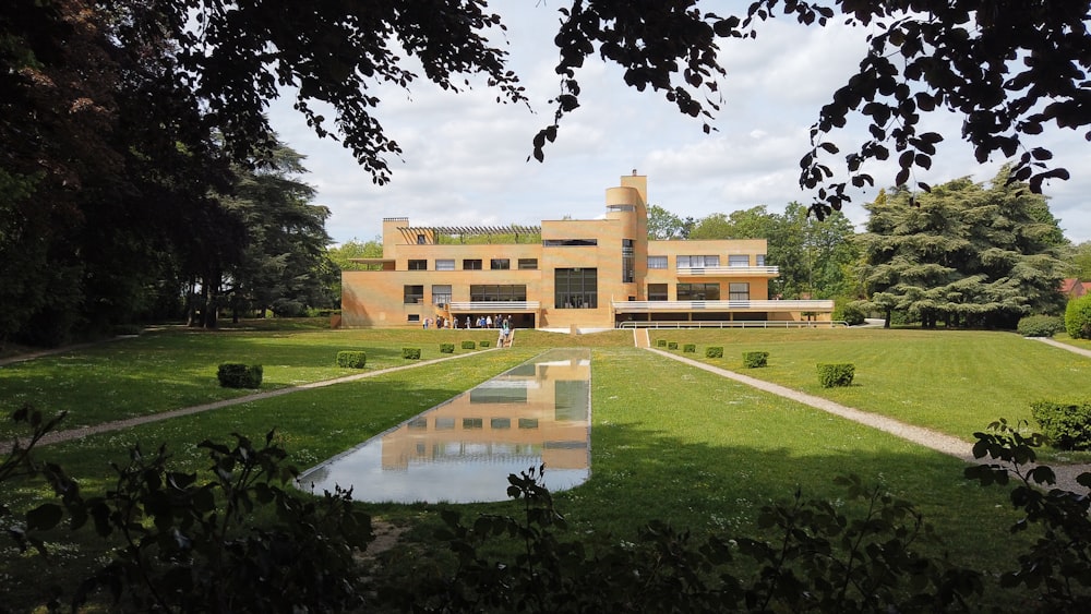 a large building with a pond in front of it