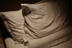 Close-up of fluffy pillows stacked on a bed with textured pillowcases.