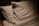 Two white pillows resting on a bed with soft lighting casting shadows. The bedding appears smooth and neatly arranged, creating a cozy and inviting atmosphere.