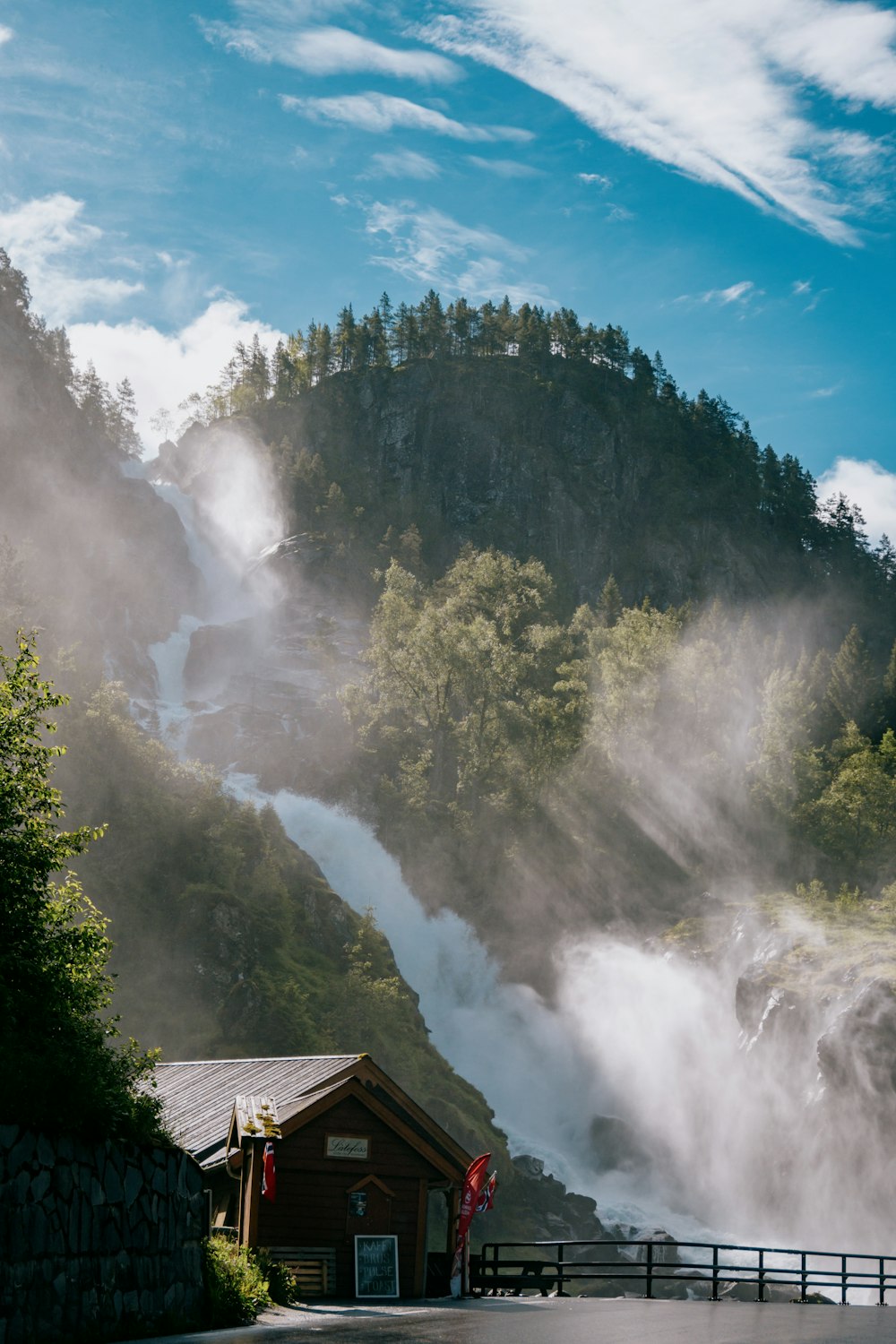 a waterfall with a building and trees