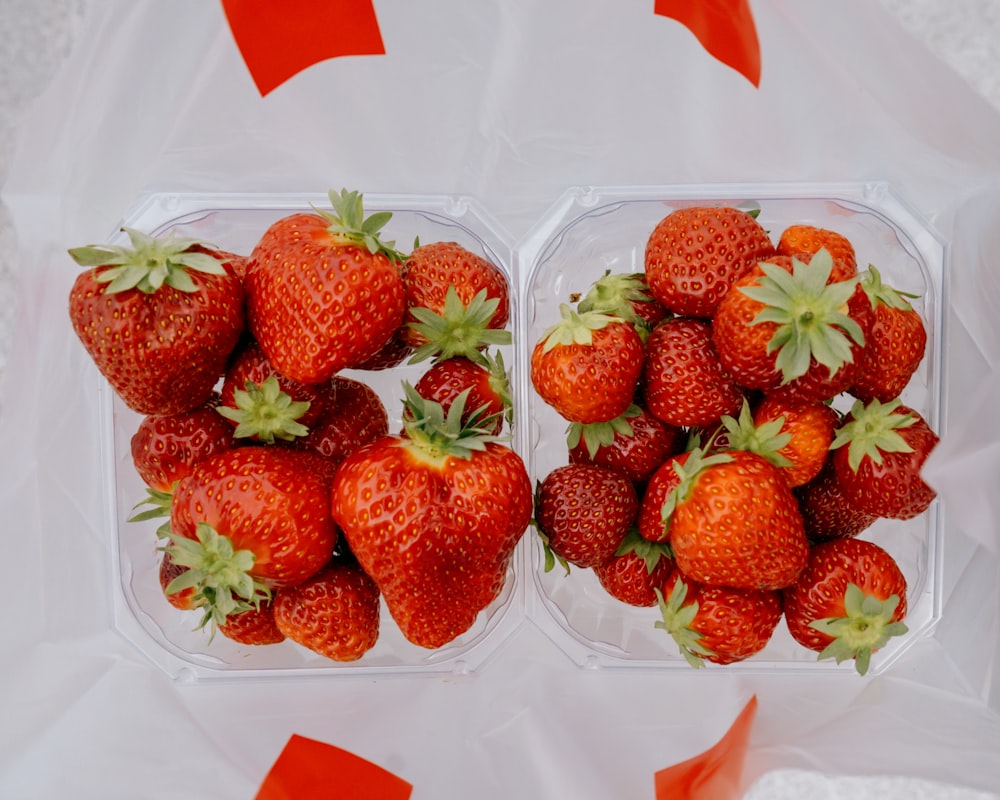 a couple of red containers with strawberries in them