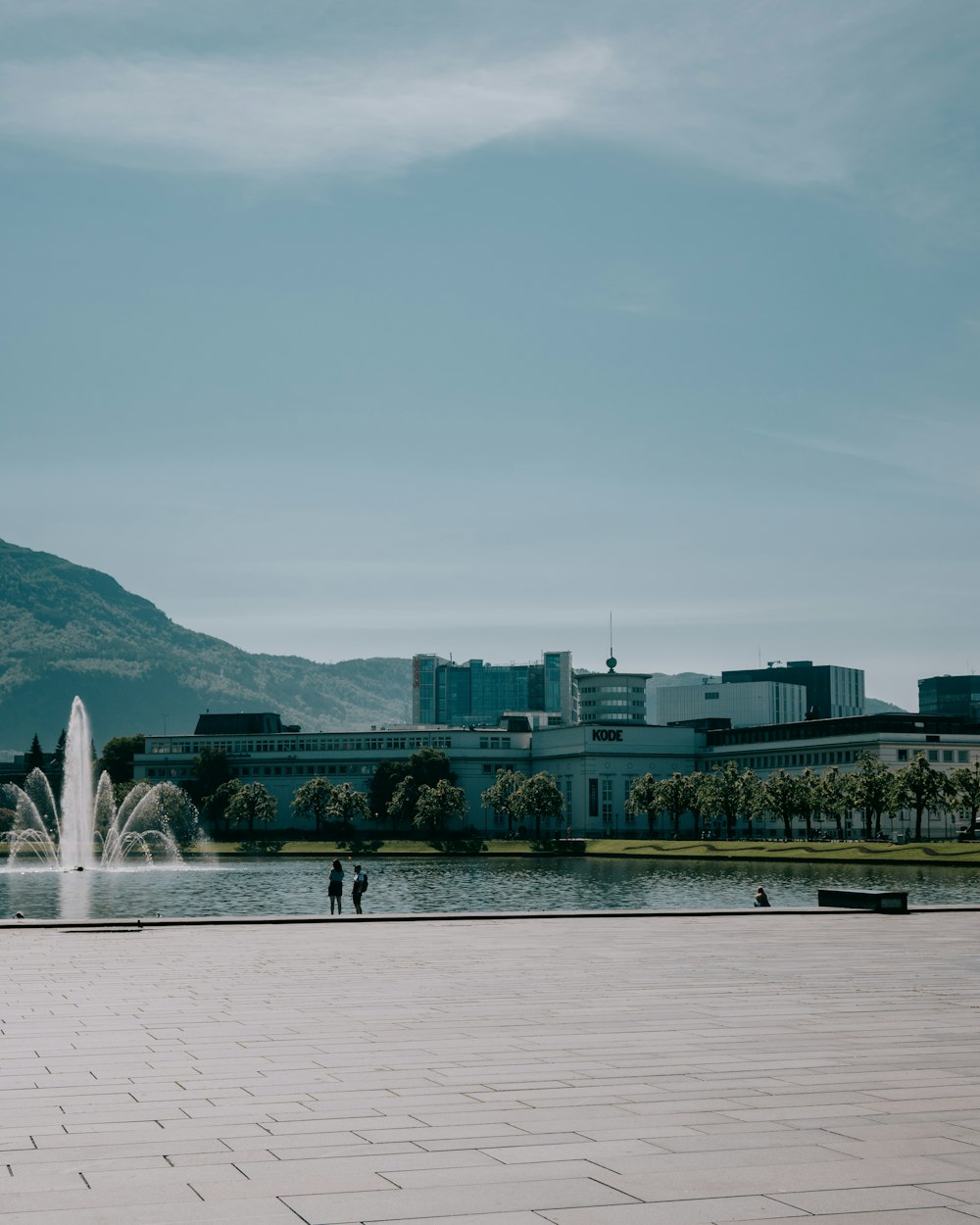 a fountain in front of a large building with a large body of water