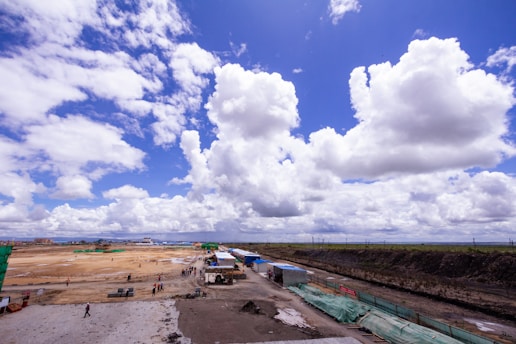A dynamic construction site with workers and heavy machinery under a clear blue sky.