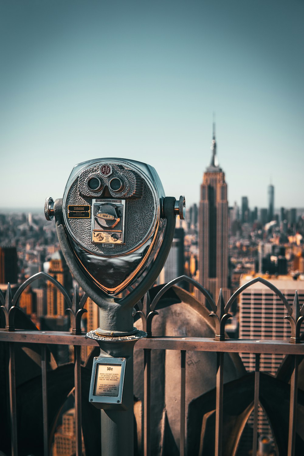 a metal object with a face on it with a city in the background
